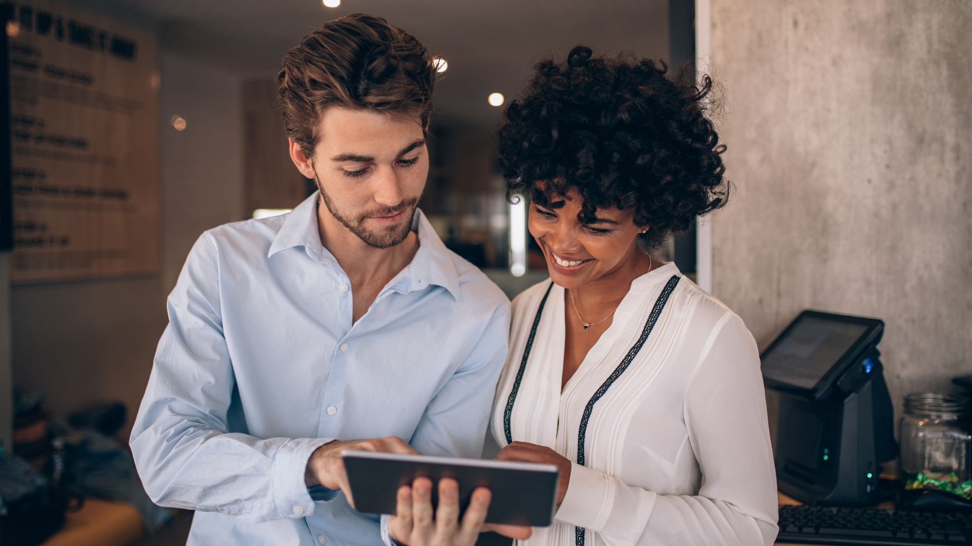 Duas pessoas olhando para um tablet debatendo resultados de marketing.