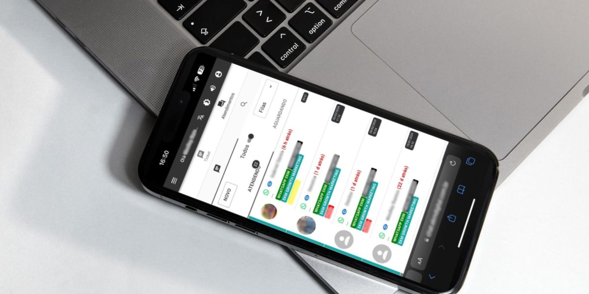 Um iphone sobre um macbook em uma mesa, mostrando a tela do EkmChat com todos os canais de atendimento centralizados.