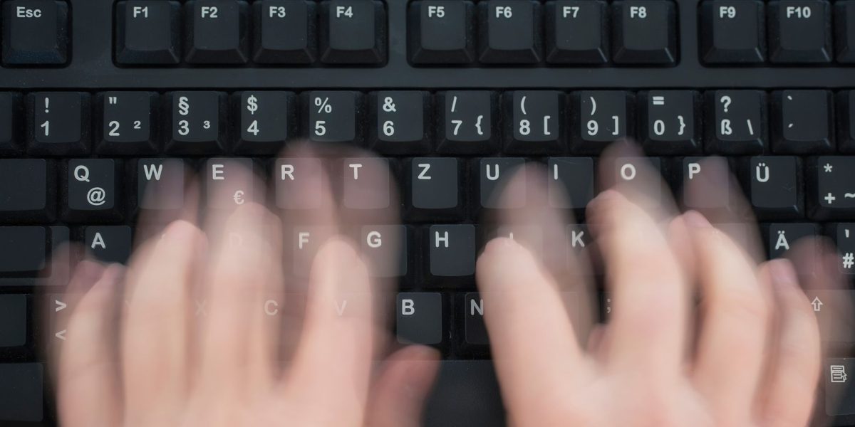 Mão digitando rapidamente no teclado do computador para simular como melhorar o tempo de resposta ao cliente.